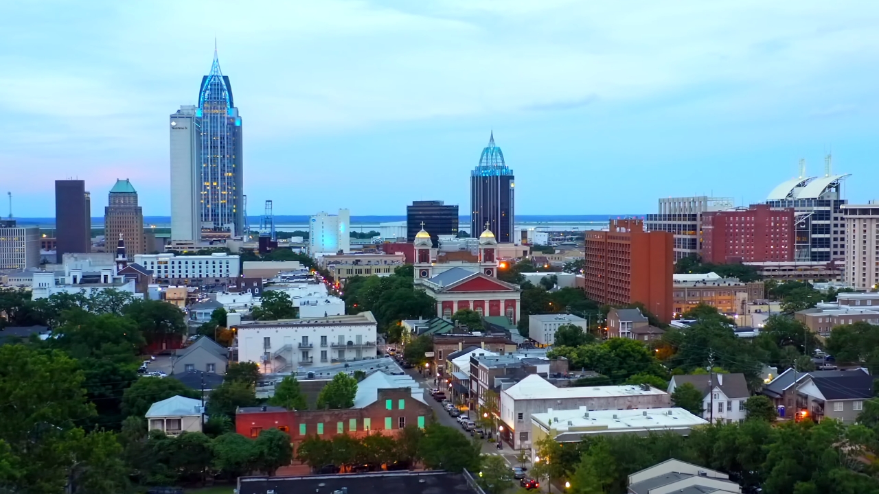 City skyline in Alabama with downtown buildings, streets, and evening lights