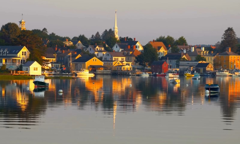 A scenic view of a small New Hampshire town featuring houses and boats along the waterfront