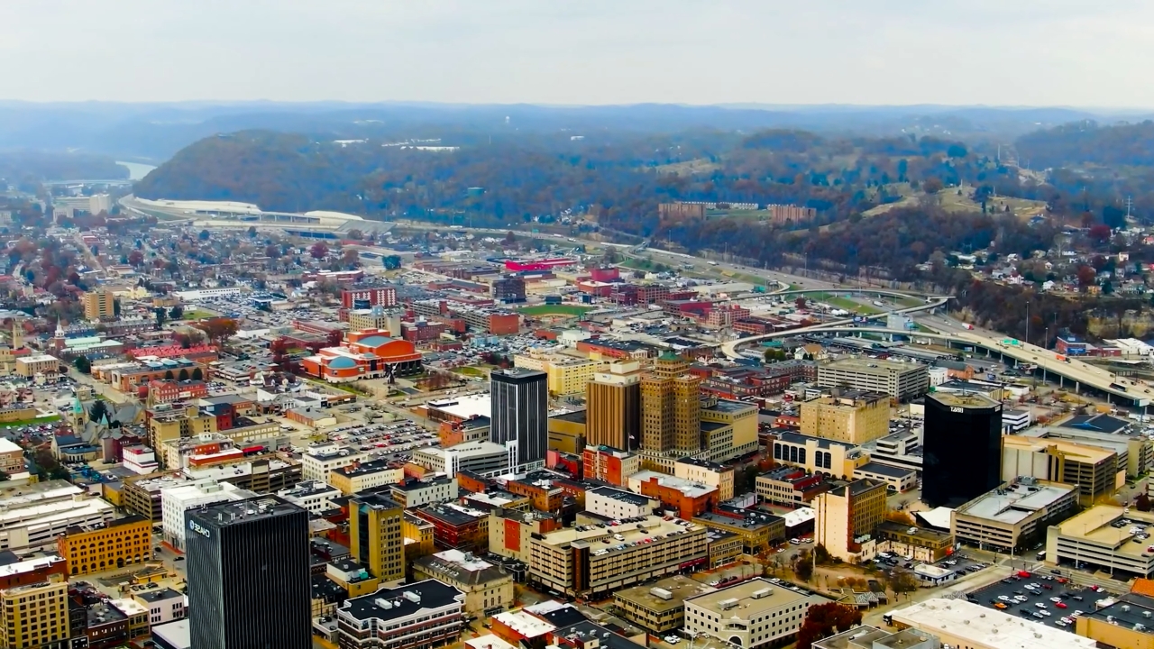 Aerial view of a small West Virginia city with downtown buildings, roads, and surrounding hills