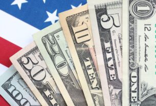 US dollar bills on American flag representing average salary in the US by state in 2026