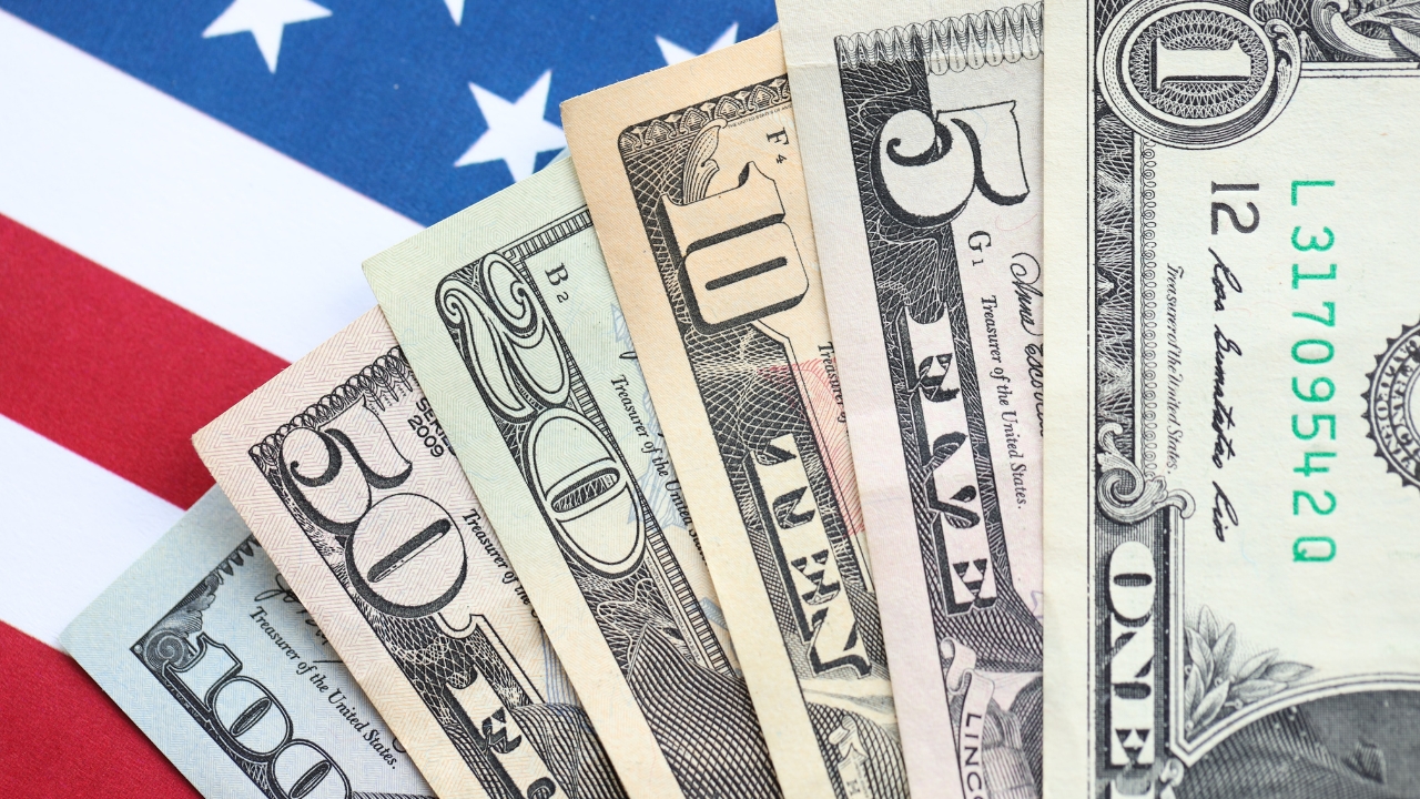 US dollar bills on American flag representing average salary in the US by state in 2026