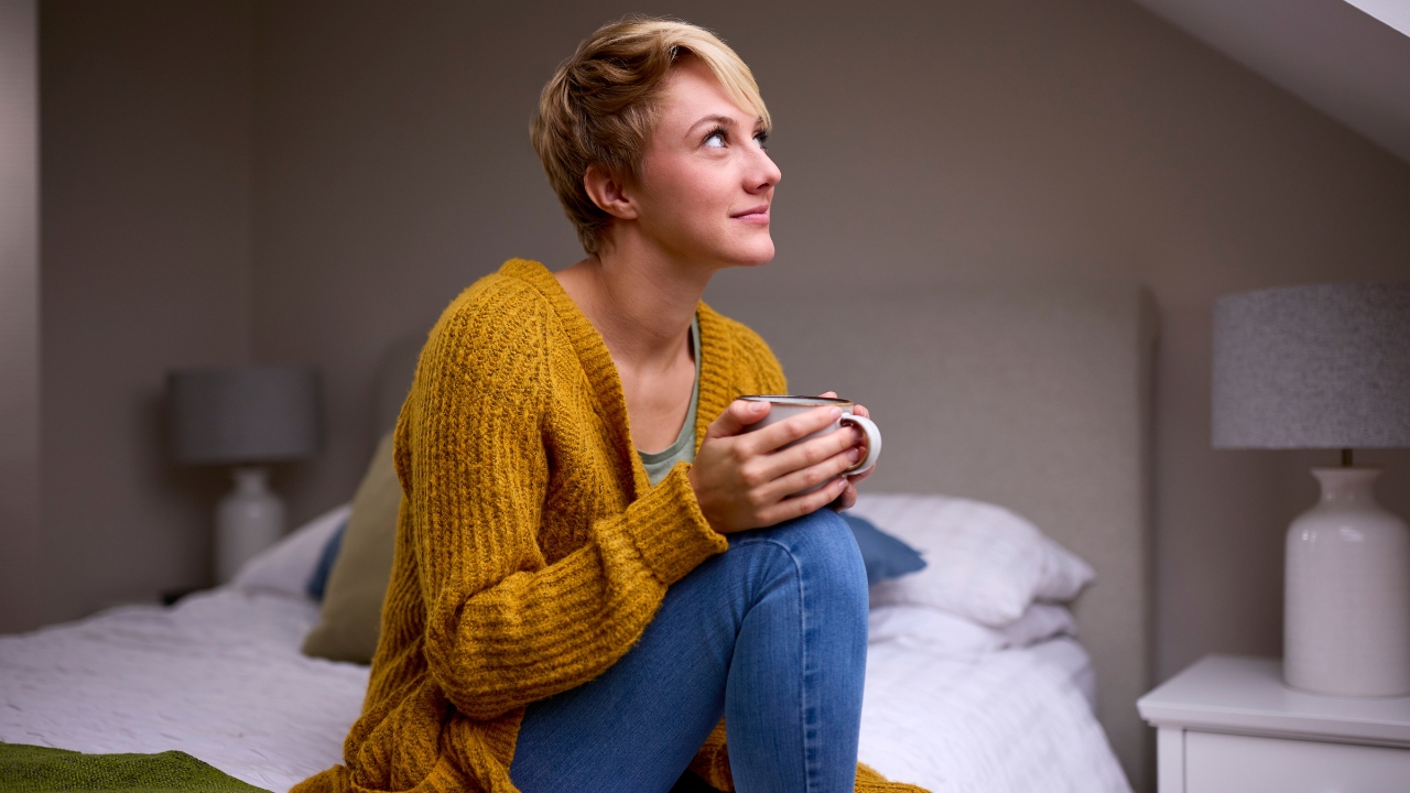 A single renter sits in a one-bedroom apartment and thinks about rent affordability in major U.S. cities