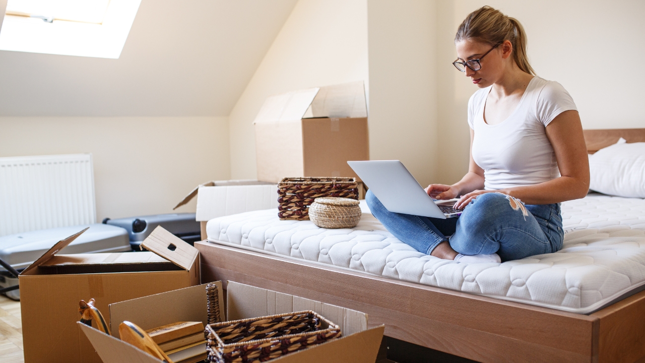 A single renter checks housing costs on a laptop after move-in